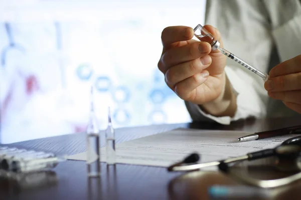 Un hombre firma un documento médico. Equipo médico sobre la mesa . —  Fotos de Stock