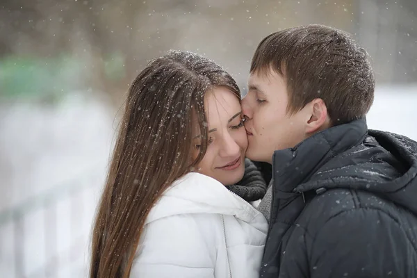 Par de amantes em uma tarde de inverno de data em uma nevasca de neve — Fotografia de Stock