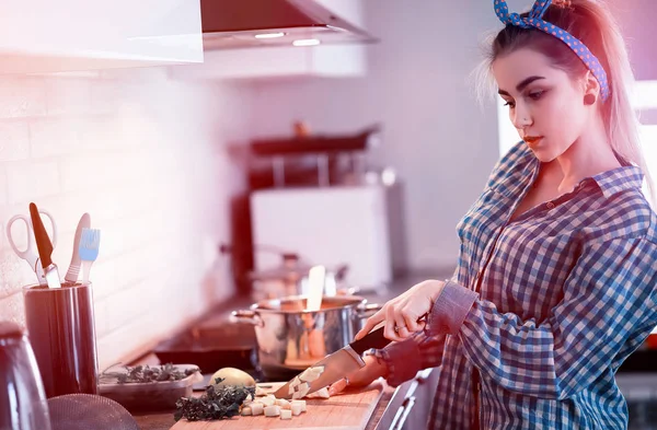 A cute young girl in the kitchen prepares food — Stock Photo, Image