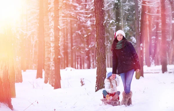 Un cuento de hadas de invierno, una joven madre y su hija montan en un trineo — Foto de Stock