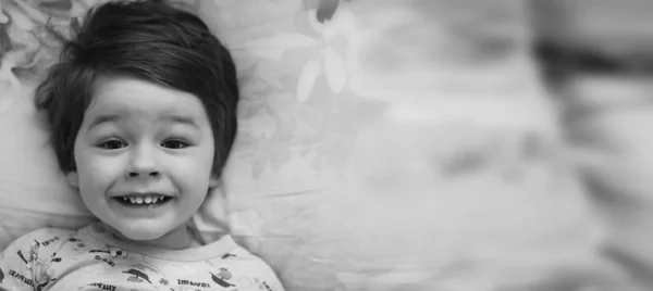 Black and white photo portrait of a young child lying on a pillo — Stock Photo, Image