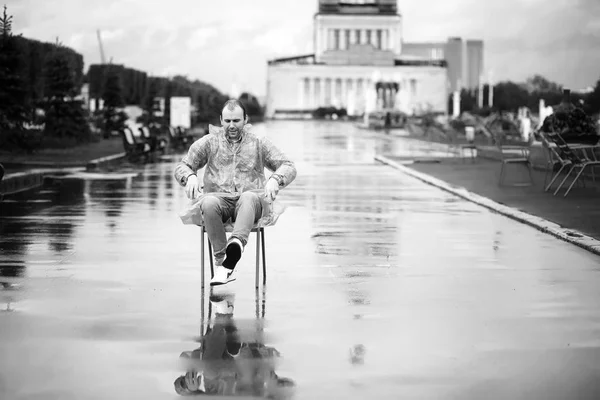 Een man in een regenjas in de stad — Stockfoto