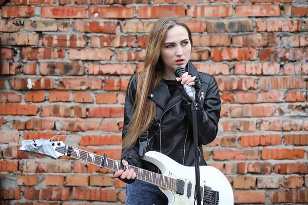 A rock musician girl in a leather jacket with a guitar — Stock Photo, Image