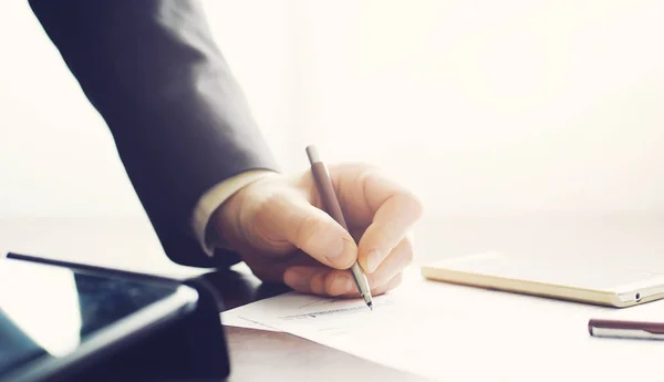 Business meeting. A man signs a contract. Male hand with pen mak — ストック写真