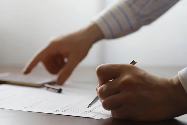 Zakelijke bijeenkomst. Een man tekent een contract. Mannelijke hand met pen mak — Stockfoto