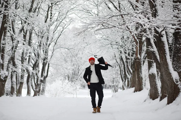 Un hombre en un paseo por el parque. Joven con en el invierno snowfa — Foto de Stock