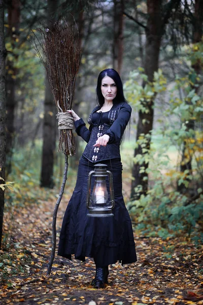 Une femme en costume de sorcière dans une forêt — Photo