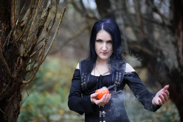 Una mujer con un traje de bruja en un bosque —  Fotos de Stock