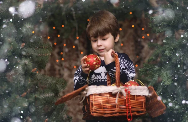 Un niño pequeño junto al árbol de Año Nuevo. Los niños decoran el Chris —  Fotos de Stock