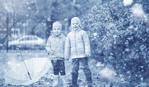 Les enfants marchent dans le parc première neige — Photo