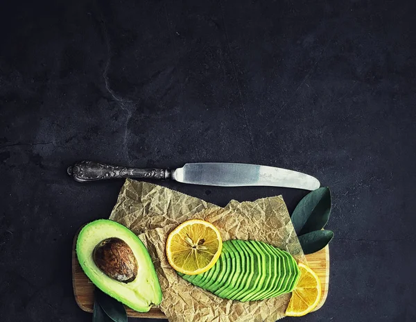 Avocado cooking recipes. Ripe green avocado on a wooden cutting — Stock Photo, Image