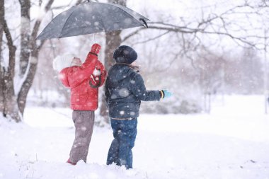 Çocuklar parkta ilk kar yürümek