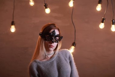 Siyah bir maske içinde sarı saçlı bir kızla