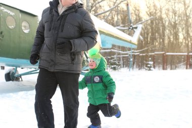Baba ve oğul kışın parkta yürüyüşe çıktılar.