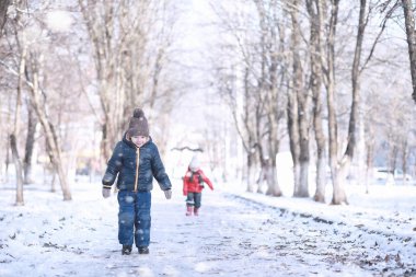 Çocuklar parkta ilk kar yürümek