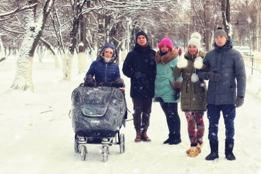 Puseti olan arkadaşlar kış parkında yürüyor. 