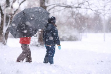 Çocuklar parkta ilk kar yürümek