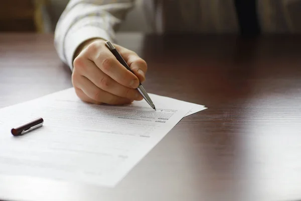 Reunión de negocios. Un hombre firma un contrato. Mano masculina con pluma mak —  Fotos de Stock