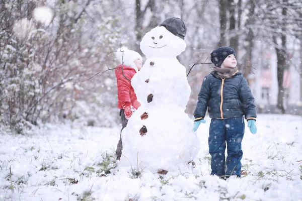 Çocuklar parkta ilk kar yürümek — Stok fotoğraf