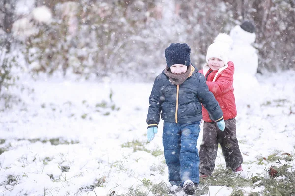 Kids walk in the park first snow — Stock Photo, Image