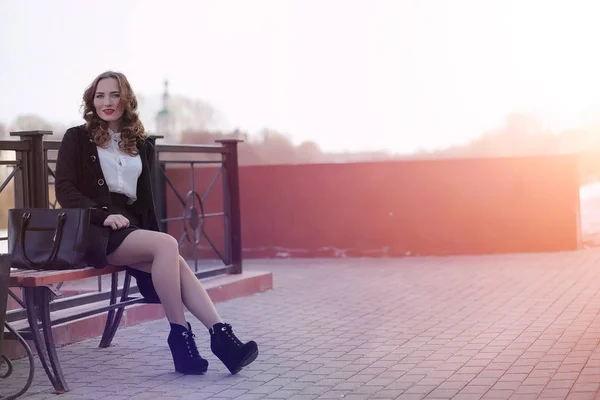 Femme d'affaires fille au printemps sur une promenade dans un manteau — Photo