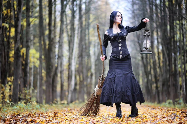 Uma mulher de fato de bruxa numa floresta — Fotografia de Stock
