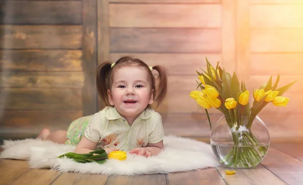 Een klein kind met een boeket van gele tulpen. Een jongen met een gift — Stockfoto