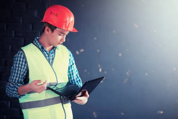 Hombre asiático en casco protector y chaleco de construcción —  Fotos de Stock