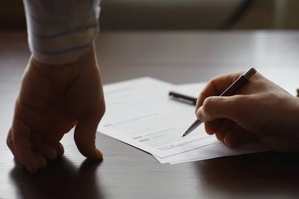 Zakelijke bijeenkomst. Een man tekent een contract. Mannelijke hand met pen mak — Stockfoto