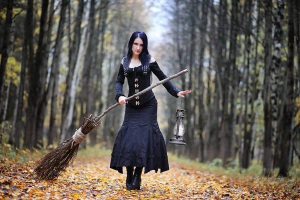 Una mujer con un traje de bruja en un bosque — Foto de Stock