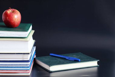 Masanın üzerinde bir yığın kitap ve ders kitabı var. Bilme konsepti