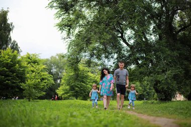İki kızı olan bir aile parkta yürüyüşe çıkmış.