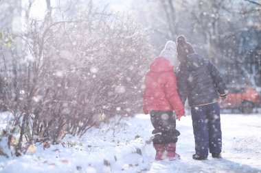 Çocuklar parkta ilk kar yürümek