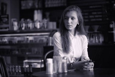 Bir kız bir kafede kahve içiyor. Bir kadın kahvaltı yapıyor