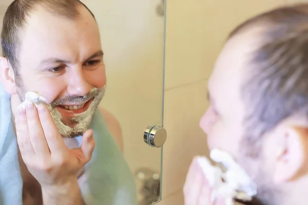 Egy férfi reggel borotválkozik a fürdőszobában. — Stock Fotó