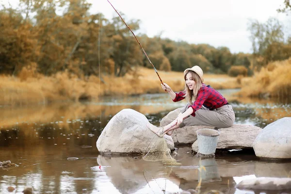 Girl in autumn with a fishing rod — Stock Photo, Image