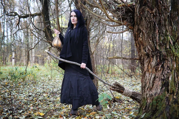 Una mujer con un traje de bruja en un bosque — Foto de Stock