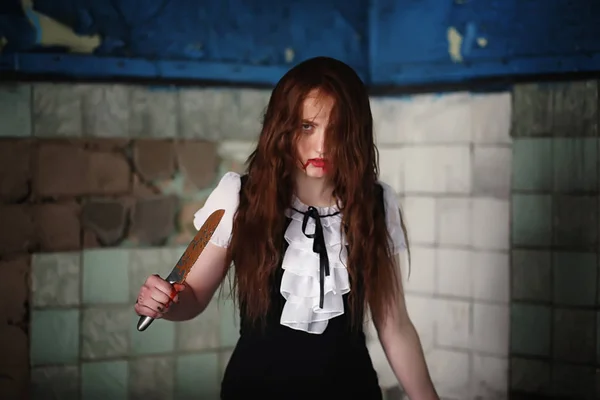 Молодая девушка в крови и с ножом — стоковое фото