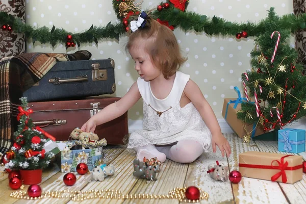 Маленькая девочка сидит перед рождественской ёлкой — стоковое фото