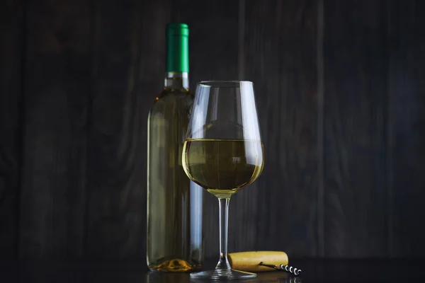 Διαφανές μπουκάλι λευκό ξηρό κρασί στο τραπέζι. Λευκό κρασί gl — Φωτογραφία Αρχείου