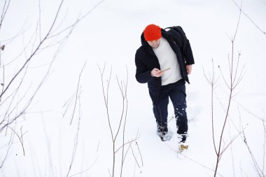 Kışın ormanda bir adam. Sırt çantalı bir turist.