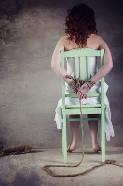 Genç kız yere bağlı. Kaçırılan kız. Kurban o