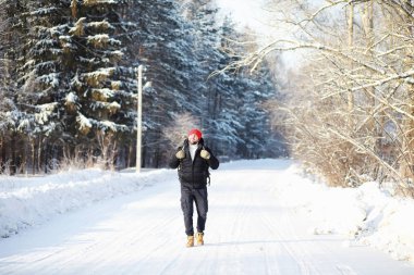 Bir adam sırt çantasıyla seyahat eder. Ormanda kış yürüyüşü. Touris