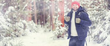 Bir adam sırt çantasıyla seyahat eder. Ormanda kış yürüyüşü. Touris