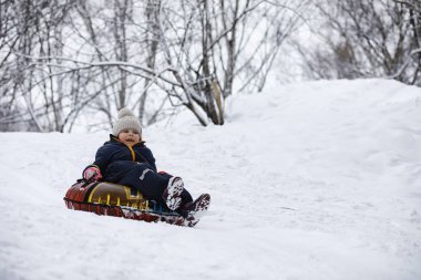 Kışın parktaki çocuklar. Çocuklar oyun oynarken karla oynuyor.