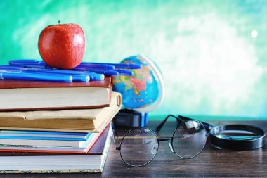 Eğitim konsepti. Bir yığın ders kitabı ve masanın üstünde bir kitap.