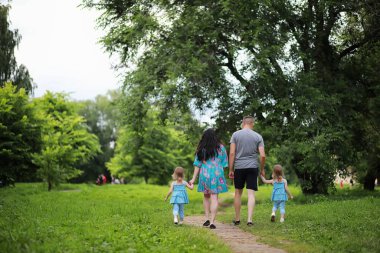 İki kızı olan bir aile parkta yürüyüşe çıkmış.
