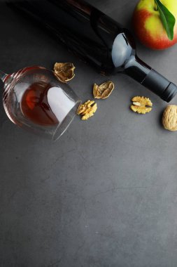 Şarap kadehi ve siyah şarap şişesi. Ceviz peyniri ve domates.