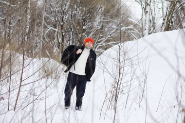 Kışın ormanda bir adam. Sırt çantalı bir turist.