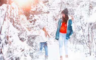 Genç bir aile yürüyüşe çıktı. Anne ve kızı şarapla yürüyorlar.